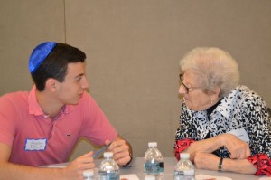 Douglas Nabert, 16, an NCSYer from Florida, talks with a woman whose husband survived Auschwitz.