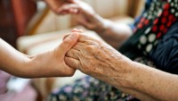 Old Lady and Young Woman Holding Hands