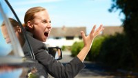 angry businesswoman in car screening at another driver