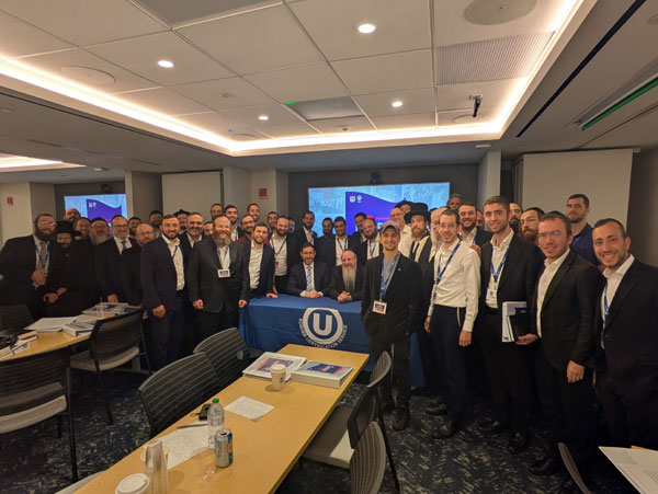 ASK OU Summer Kashrus Training Program participants, at OU headquarters in New York. Seated, in the center, are OU Kosher Managing Director of Marketing and Community Relations Rabbi Eli Eleff (left), and OU Kosher Executive Rabbinic Coordinator Rabbi Nachum Rabinowitz (right).