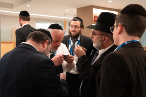 Rabbi Aharon Drebin (second from left), of Flatbush, New York, and Rabbi Mordechai Gholian (second from right), of Baltimore, Maryland, analyze fabric at the OU National Shatnez Conference.