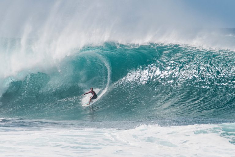 A surfer lines up a very large wave at the infamous Banzai Pipeline on the North Shore of Oahu
